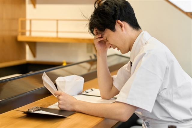 書面を見て悩む人