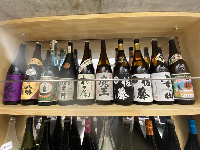 キッチン内の棚にずらりと並ぶ焼酎。