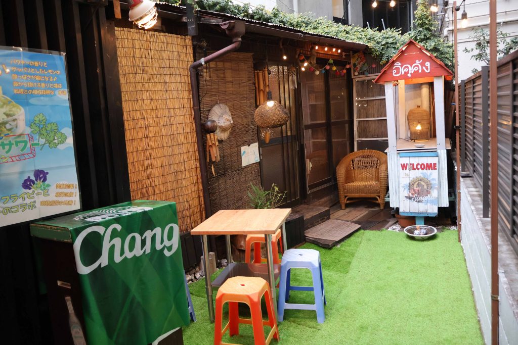 小道を抜けた先に現れるのは、トタン屋根とすだれが印象的な、ローカル食堂のような佇まい。旅先でふと出会ったような素朴でどこか懐かしい外観が、訪れる人を迎えてくれる。